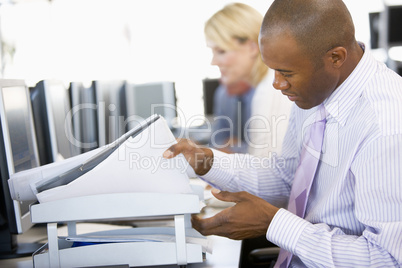 Junger Mann mit dunkler Haut sitzt am Schreibtisch