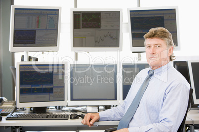 Mann sitzt vor mehreren Bildschirmen