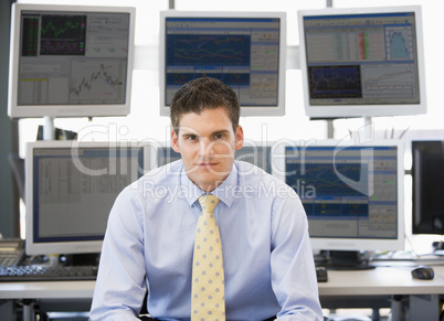 Ein junger Mann sitzt im Büro in Hemd und Krawatte