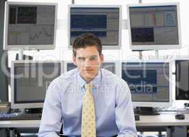 Ein junger Mann sitzt im Büro in Hemd und Krawatte