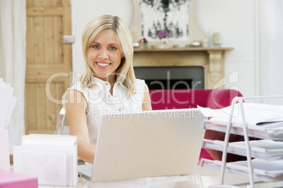 Eine junge blonde Frau sitzt am Notebook