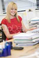 Eine blonde junge Frau arbeitet im Büro