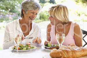 Zwei Frauen sitzen im Freien am gedeckten Tisch