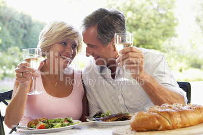 Ein Paar sitzt im Freien an einem gedeckten Tisch