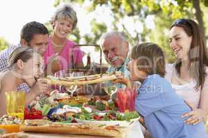 Eine Familie mit deren Goßeltern beim Picknick