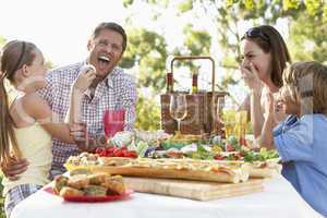 Familie lacht beim Picknick