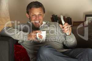 Man With Coffee Watching Television Excitedly