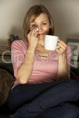 Woman Relaxing With Cup Of Coffee Watching Television