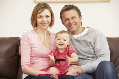 Parents And Baby Daughter On Sofa