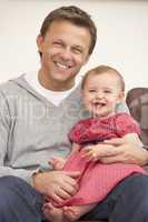 Father And Baby Daughter On Sofa