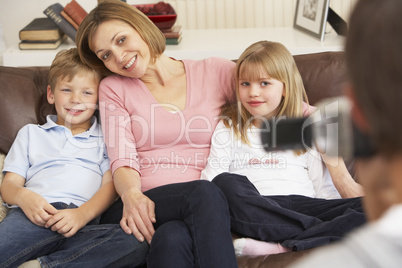 Mother And Children On Sofa Being Filmed On Video Camera