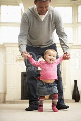 Father Helps Baby Daughter With Walking