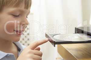 Young Boy Closing DVD Player With Finger