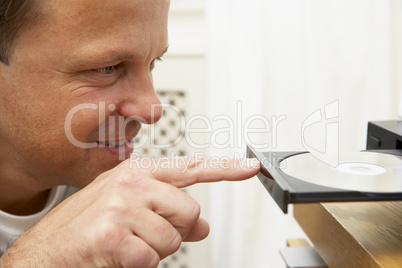 Man Closing DVD Player With Finger