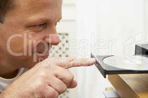 Man Closing DVD Player With Finger