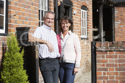 Mann und Frau stehen vor einem Haus