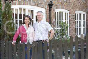 Eine brünette Frau und ein Mann stehen hinterm Zaun