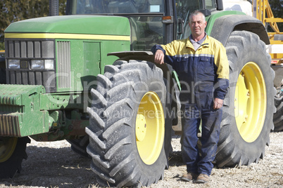 Ein Bauer steht neben seinem Traktor