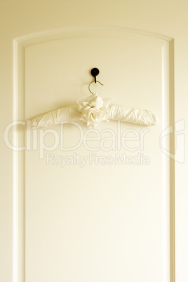 Weisser Kleiderbügel hängt an der Tür