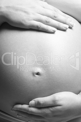 Schöner Babybauch von den Mutterhänden gehalten