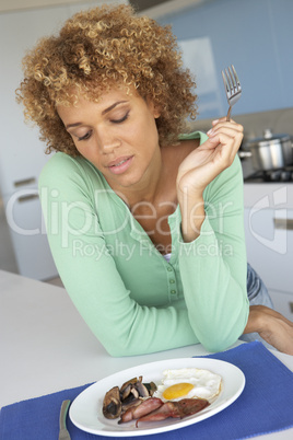 Frau sitzt gelangweilt vor einem gemischten Teller