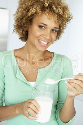Eine Frau hält ein großes Glas Milch in der Hand