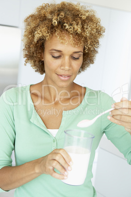 Eine Frau hält ein großes Glas Milch in der Hand