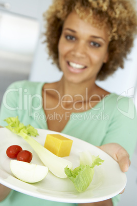 Frau hält einen Teller mit Rohkost