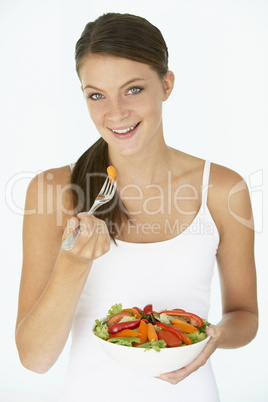 Eine junge Frau hält eine große Schüssel Salat