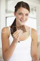 Eine junge Frau hält eine Tafel Schokolade