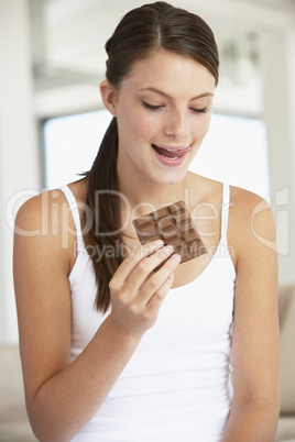 Eine junge Frau hält eine Tafel Schokolade