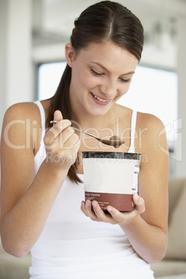 Eine junge Frau hält einen großen Becher Schokoeis