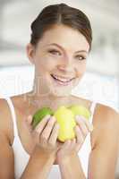 Eine junge Frau hält drei Zitronen in den Händen
