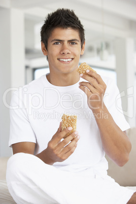 Ein junger Mann hält ein Vollkornbrötchen in der Hand