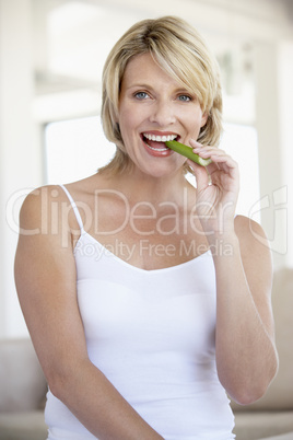 Frau beißt in grünes rohes Gemüse