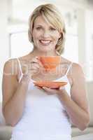 Blonde Frau mit oranger Kaffetasse