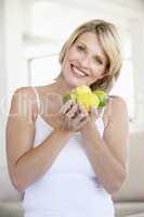 Eine junge blonde Frau mit Zitronen in den Händen