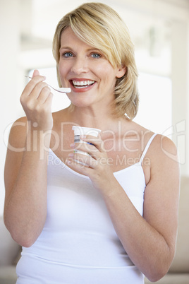 Eine junge blonde Frau mit einem Joghurt