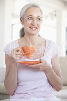 Frau mit langen grauen Haaren trinkt Kaffee