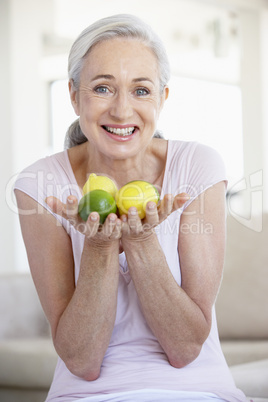 Eine Frau hält 3 Zitronen in den Händen