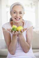 Eine Frau hält 3 Zitronen in den Händen