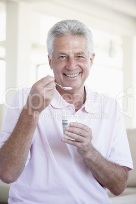 Ein Mann hält einen Joghurt in der Hand