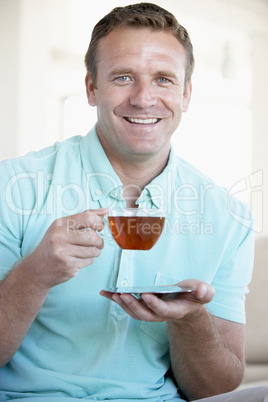 Ein Mann hält eine Tasse Tee