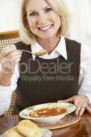 Blonde Frau ist einen Teller Suppe