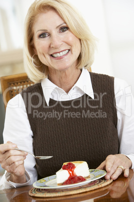 Eine blonde Frau freut sich auf ein Stück Kuchen