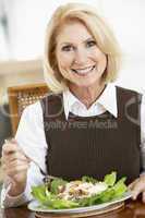 Eine blonde Frau mit einem Salatteller