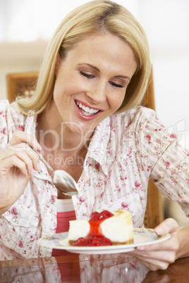 Eine blonde Frau freut sich auf ein Stück Kuchen