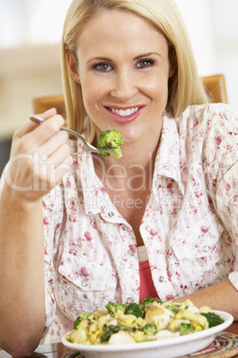 Eine blonde Frau genießt einen Teller Gemüse