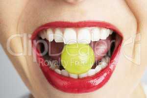 Roter Mund mit Weintraube zwischen den Zähnen