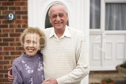 Altes glückliches Ehepaar vor ihrem Haus